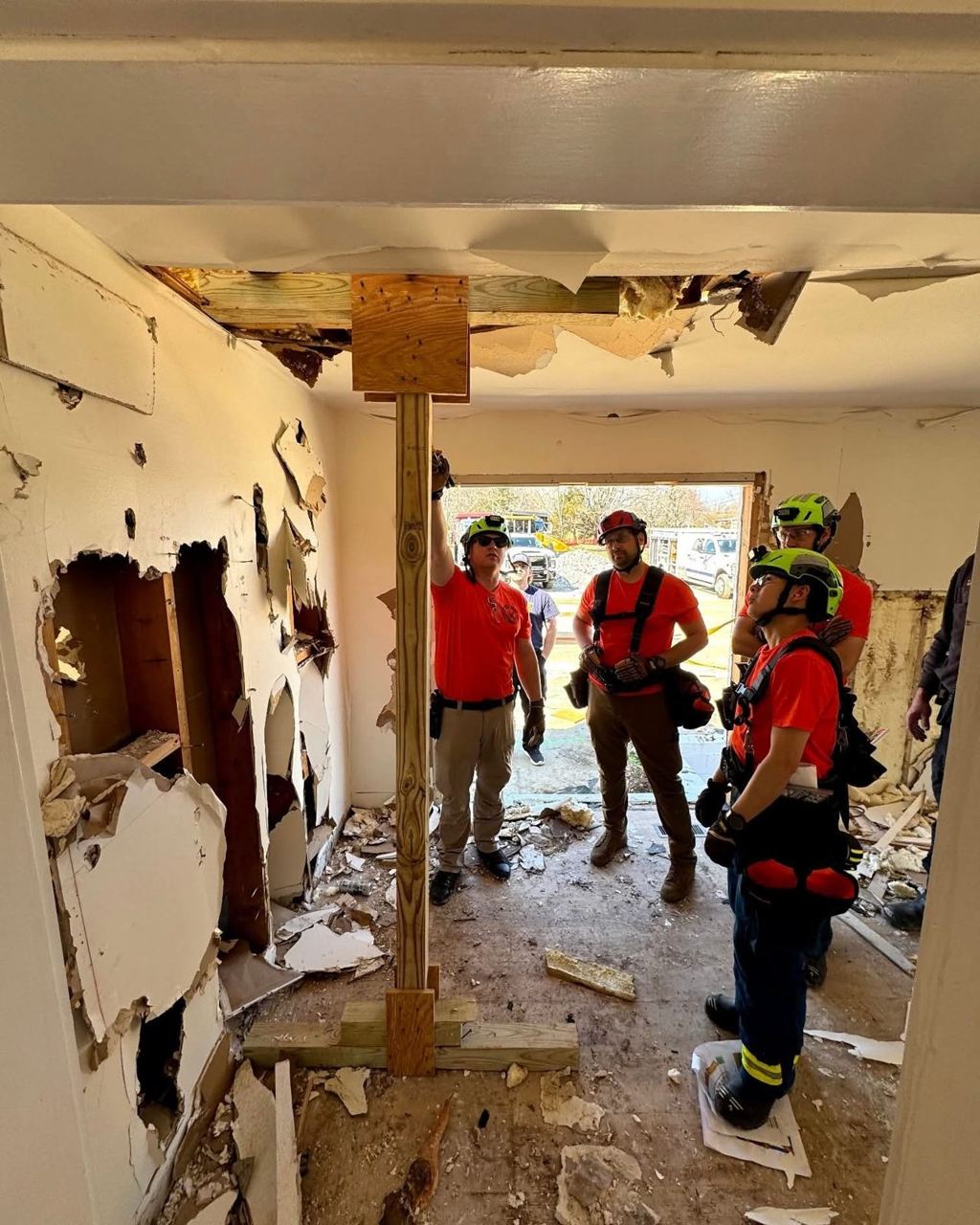 Members shoring a structure during structural collapse training