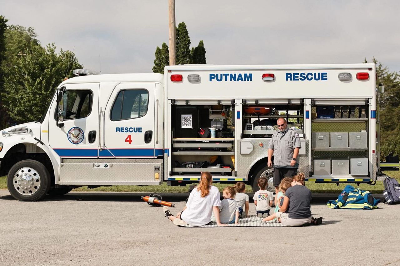 Rescue 4 truck at a community event with children seated nearby