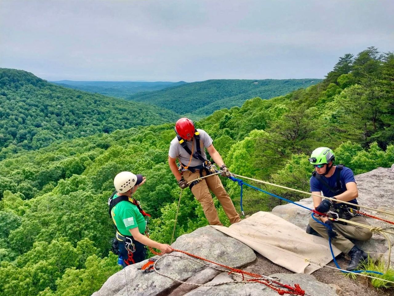 Members running a high-angle rope rescue system on a clifftop