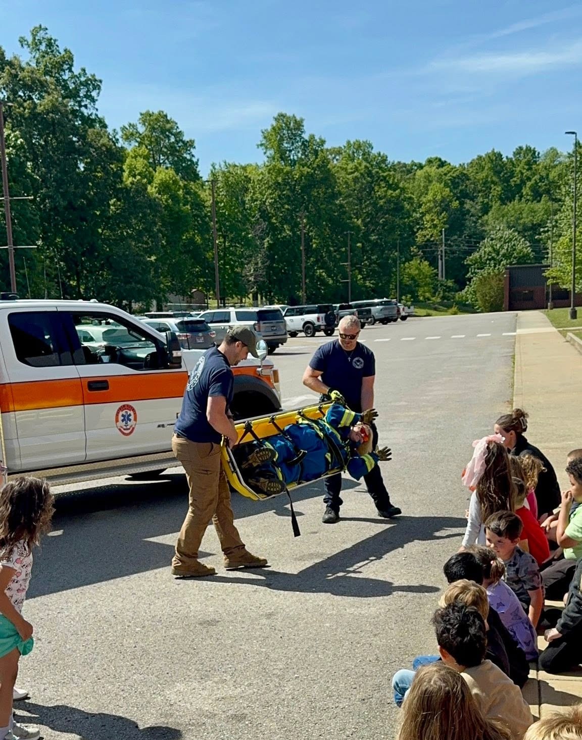 Members demonstrating medical stretcher use at a youth community event